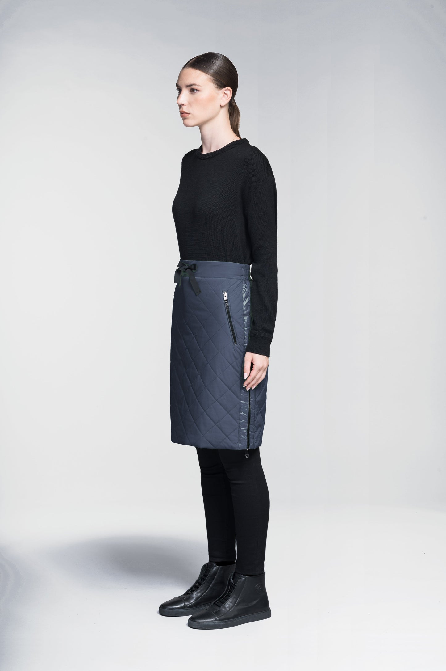 Phora Women's Tailored Skirt in knee length, premium stretch ripstop and contrast cire technical nylon taffeta fabrication, premium 4-way stretch, water resistant Primaloft Gold Insulation Active+, elasticated waistband with grosgrain ribbon drawstrings, two zipper pockets at waist, and zipper closure gusset at side seams, in Marine