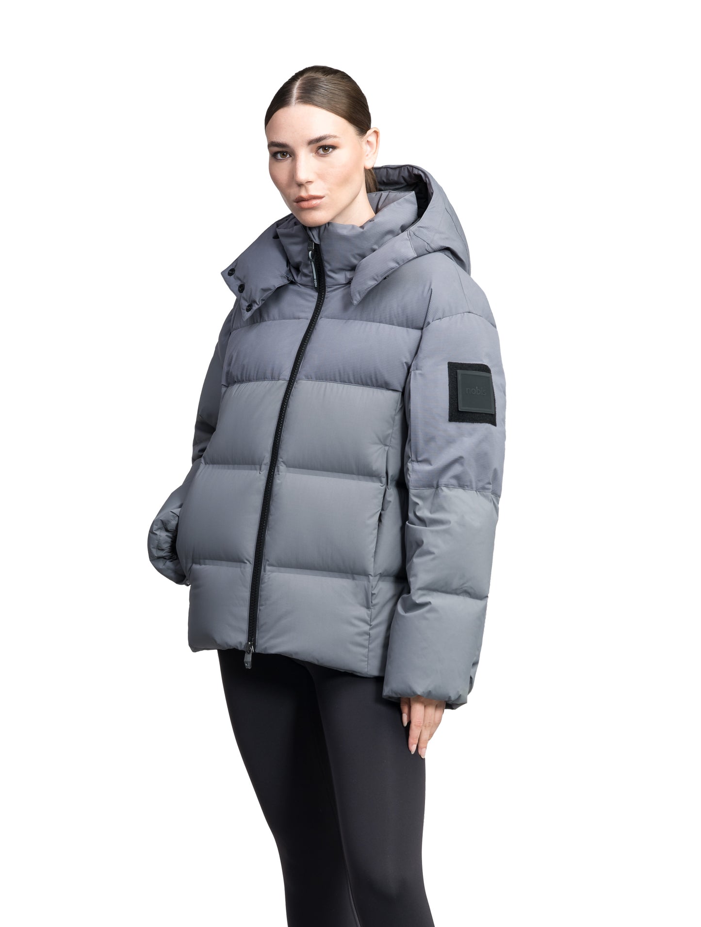 Una Ladies Performance Puffer in hip length, Technical Taffeta and Durable Stretch Ripstop fabrication, Premium Canadian White Duck Down insulation, removable down filled hood, centre front two-way zipper, and side-entry pockets at waist, in Concrete