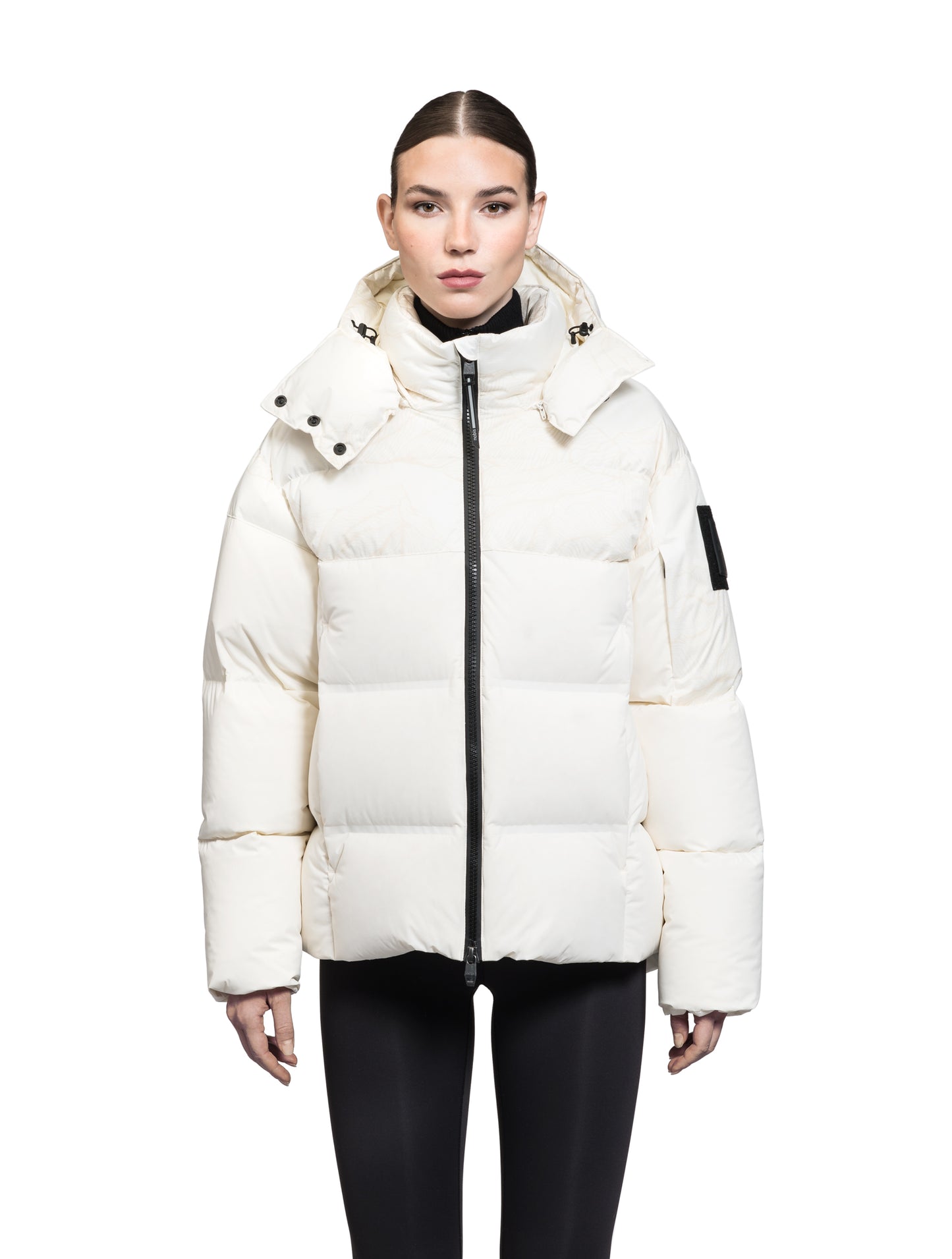 Una Ladies Performance Puffer in hip length, Technical Taffeta and Durable Stretch Ripstop fabrication, Premium Canadian White Duck Down insulation, removable down filled hood, centre front two-way zipper, and side-entry pockets at waist, in Wheat Desert